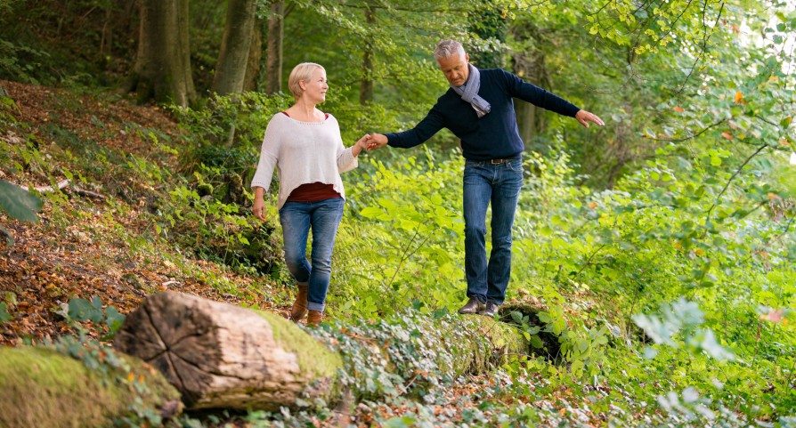 Protection des joueurs: Une femme donnant la main à un homme en équilibre sur un tronc d'arbre Frau hält Mann, der über einen Baumstamm balanciert, die Hand. Une femme donnant la main à un homme en équilibre sur un tronc d'arbre. Una donna tiene la mano a un uomo in equilibrio su un tronco d'albero.